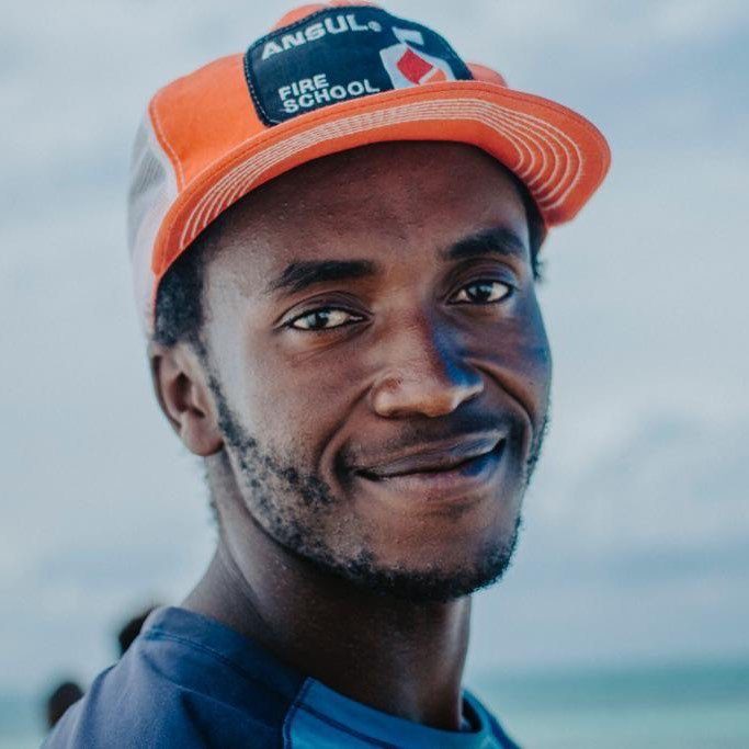 Portrait of Frank Temu, kitesurfing instructor, smiling in an orange cap